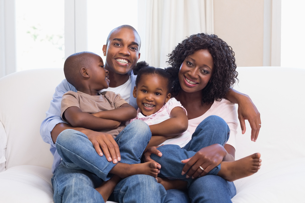 Happy family posing on the couch together at home in the living room with visas