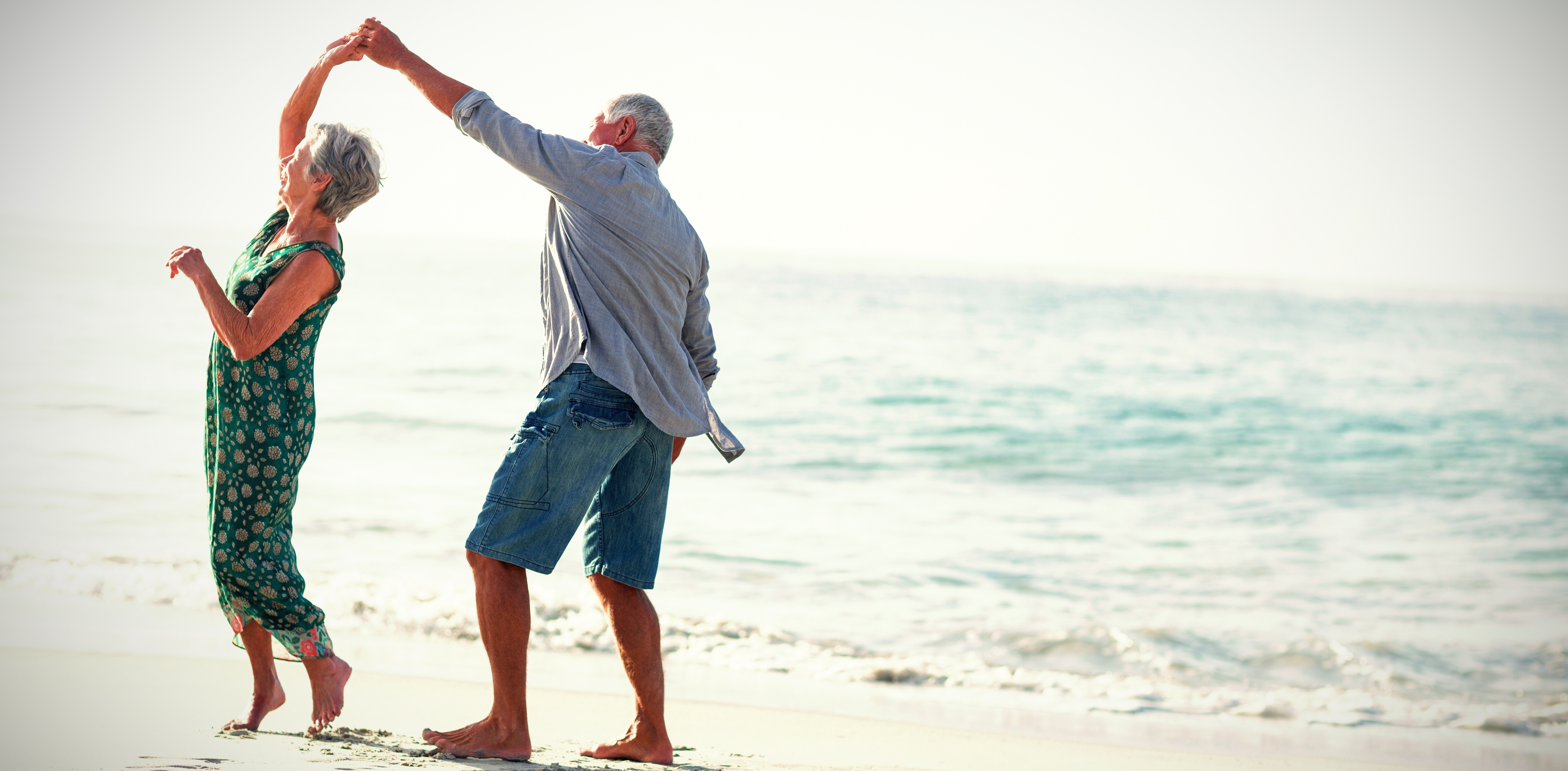 Retired couple in south africa on a beach dancing